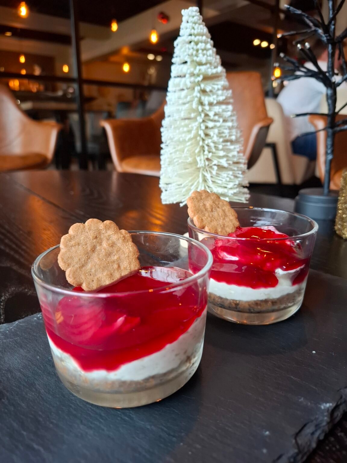 Cheesecake på brunkagebund, toppet med kirsebærsauce og brunkage